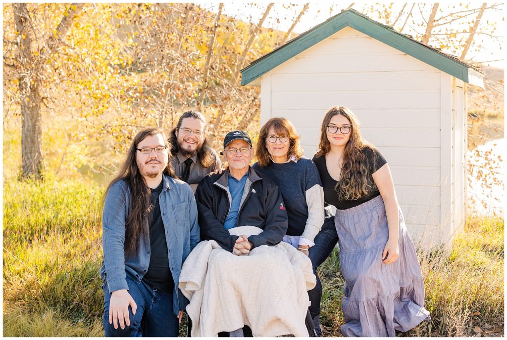 Family gathers around their husband and dad for a family session in Longmont, CO