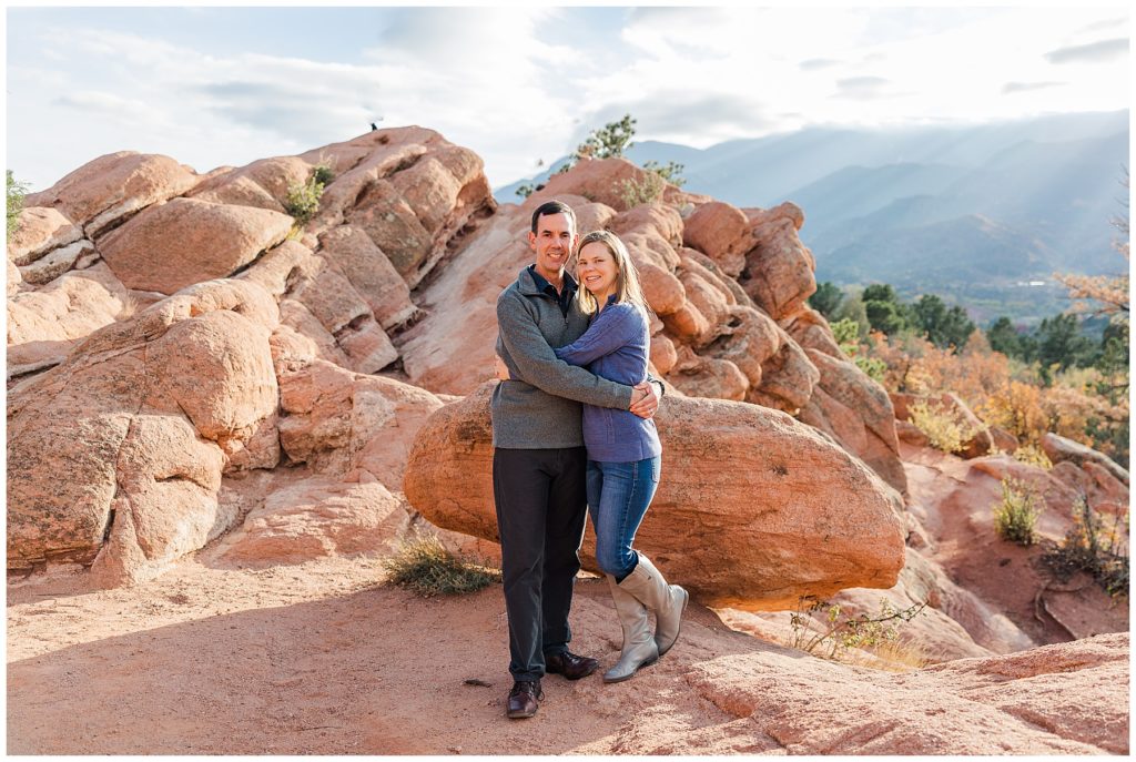 husband and wife hug for a pose in Garden of the Gods for fall family mini sessions