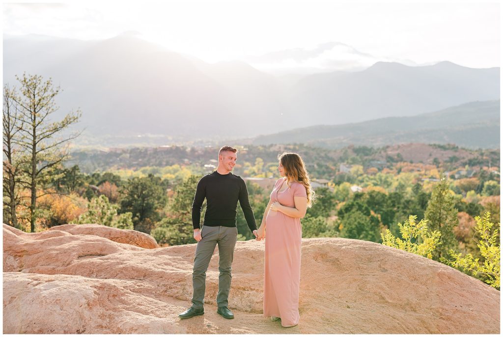 maternity session at Garden of the Gods with husband and wife holding hands and looking at each other 