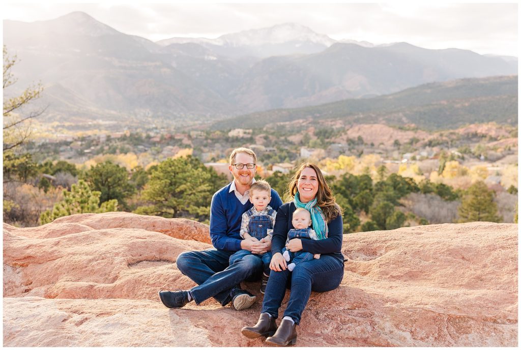 family of four sit together for family photoshoot at Garden of the Gods
