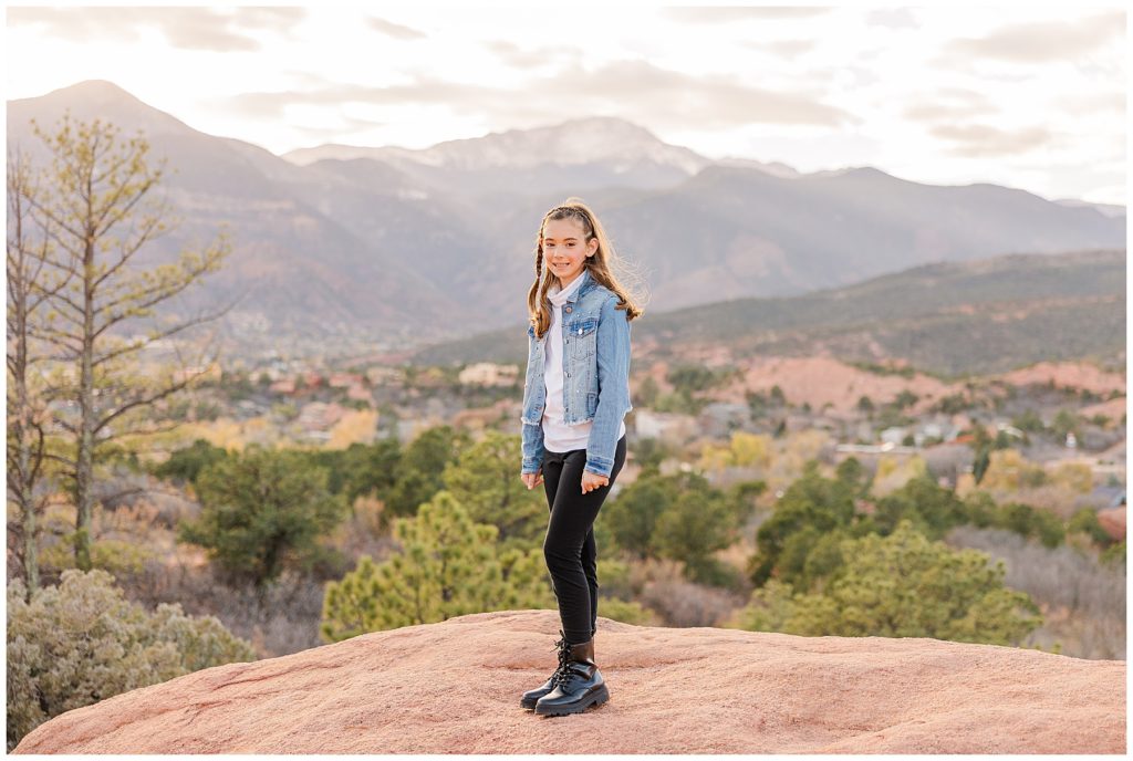 preteen at fall family mini session standing on a rock formation 