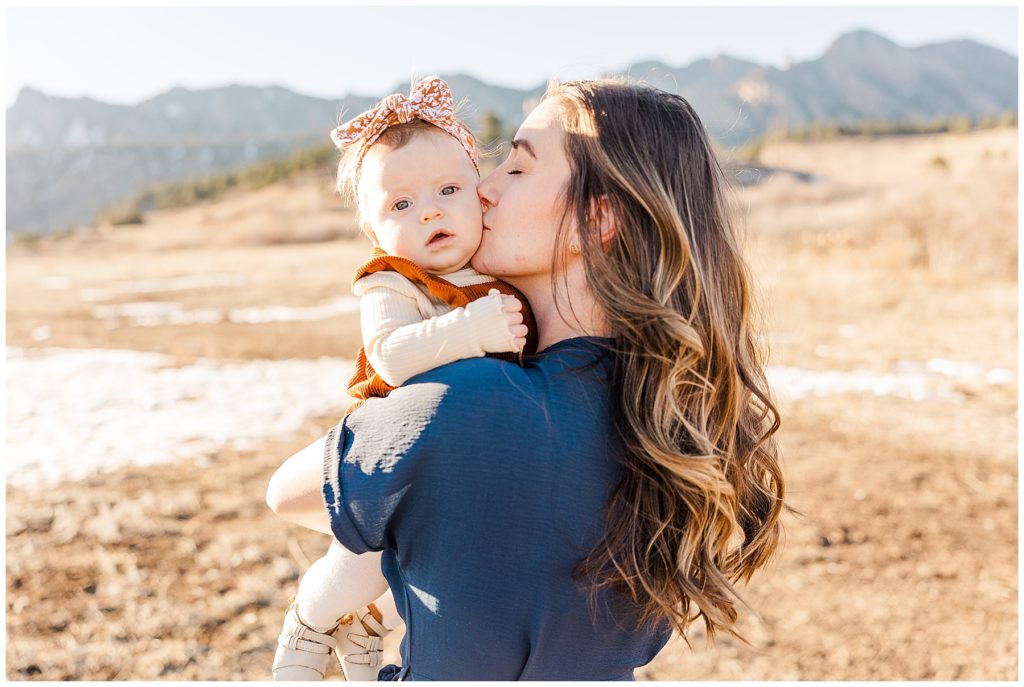 mom kisses her baby daughter on the cheek during fall family sessions in Boulder Colorado 
