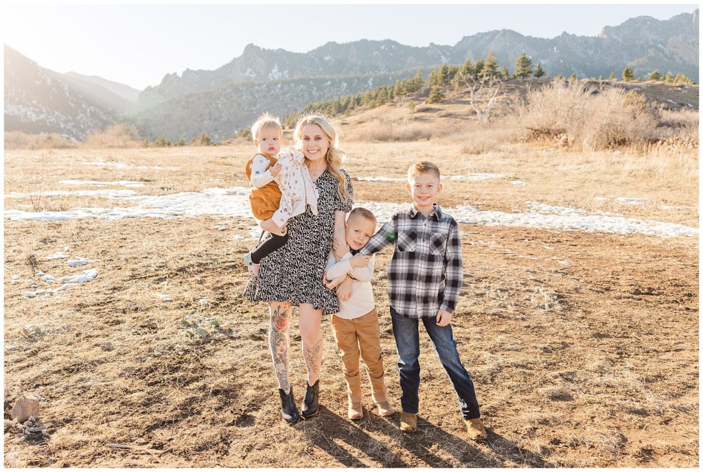 mom and her three children stand posing in front of flat irons in a golden meadow for Cohen Extended Family Session