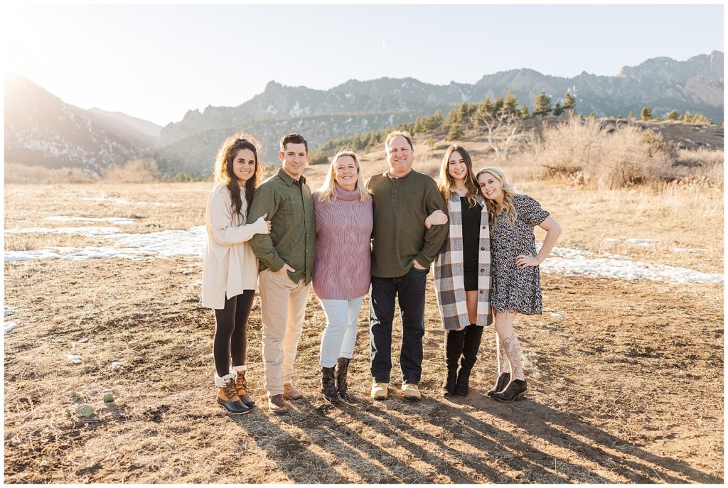 mom, dad, and their four children stand linking arms for outdoor pictures in Northern Colorado in November