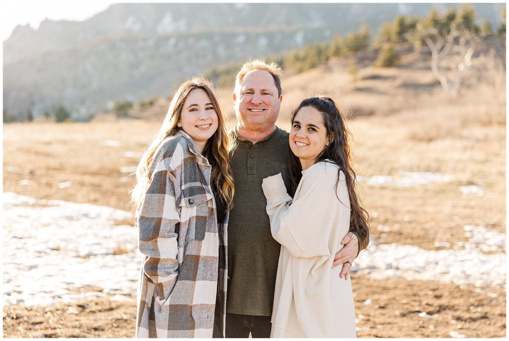 father stands with his two daughters in front of flat irons for Cohen Extended Family Session