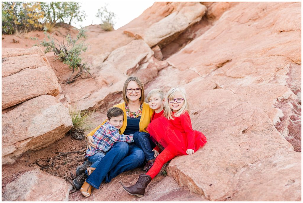 Mom of three sits with her kids in the crevice of a rock formation