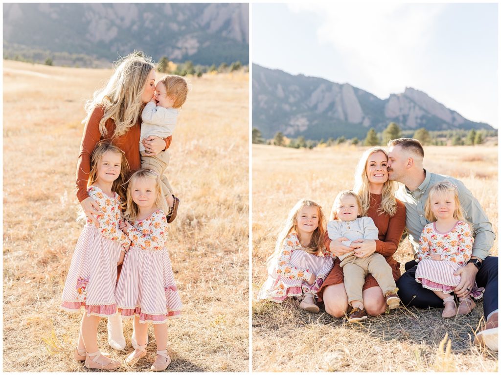 Husband kisses his wife while posing on ground in a field with their three childrens for family portraits in Boulder, CO