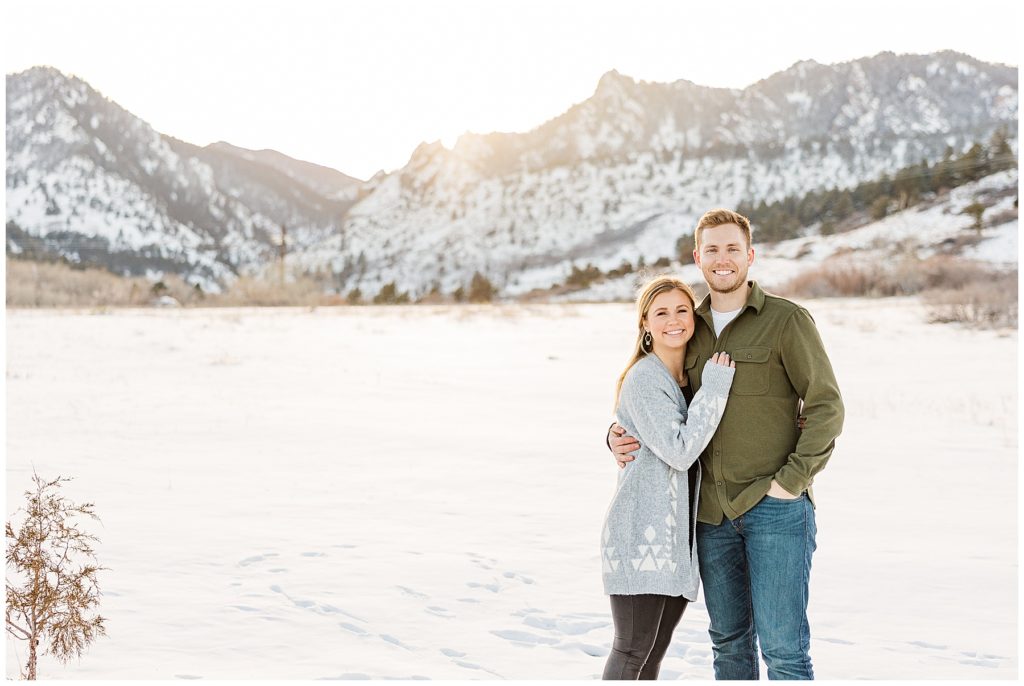 Couple faces the camera during a romantic snowy winter session in Colorado