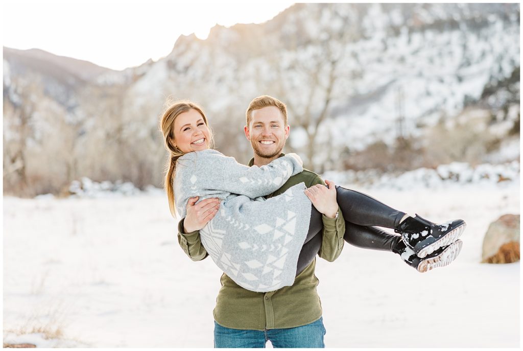 Boyfriend holds his girlfriend up in winter photo session by family photographer Catherine Chamberlain