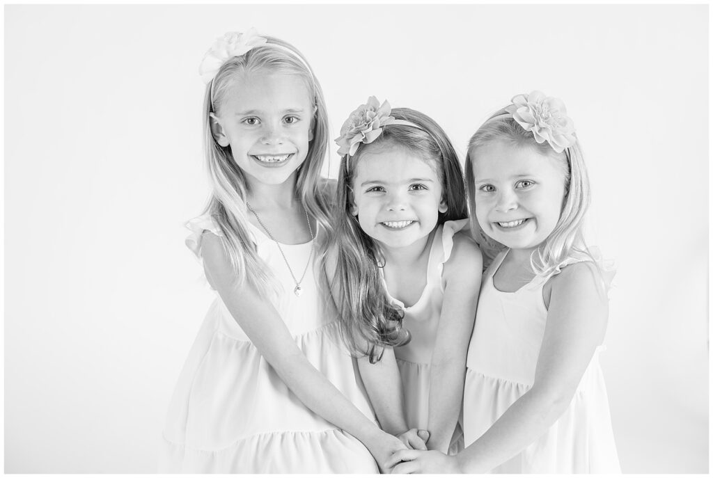 Three girls hold hand for black and white photos in Longmont, Colorado at Sugarhill Studio