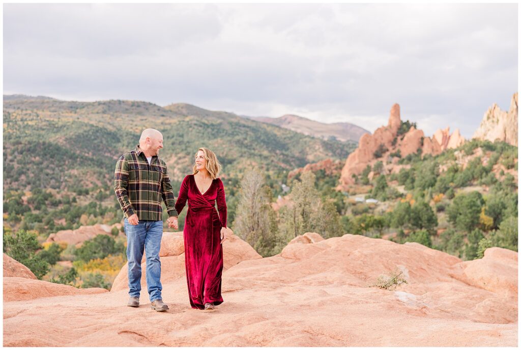 Couple holds hands and looks at each other in this wide shot taken in Garden of the Gods