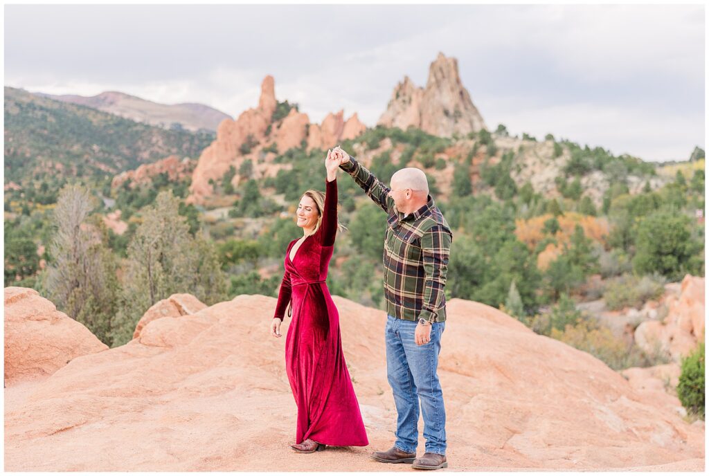 Husband twirls his wife on red rock formations for Colorado Outdoor Family Session