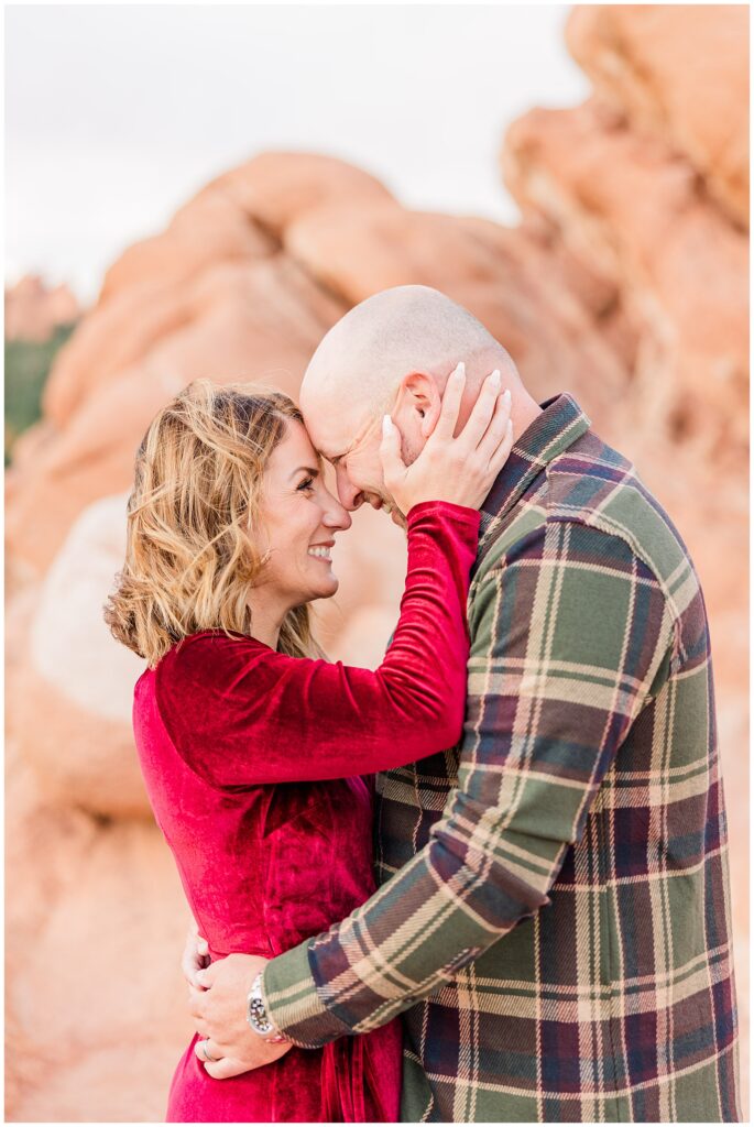Close up of couple touching foreheads as wife tenderly grabs her husbands face for Northern Colorado outdoor family session photos