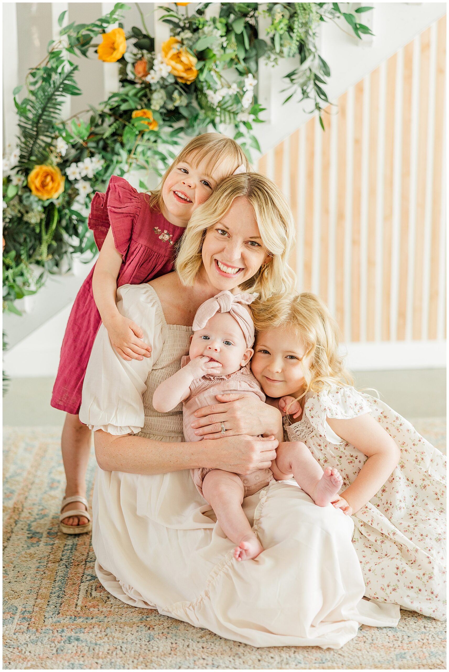 Mother with three girls pose on the floor during a Mother's Day mini session
