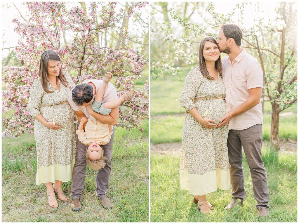 Expecting mom puts her hand under her belly and stands next to her husband who is holding their toddler son upside down during the Peterson Family Maternity Session