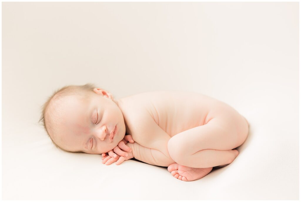 Baby poses cured in the fetal position during Conklin Family newborn session in Longmont, CO