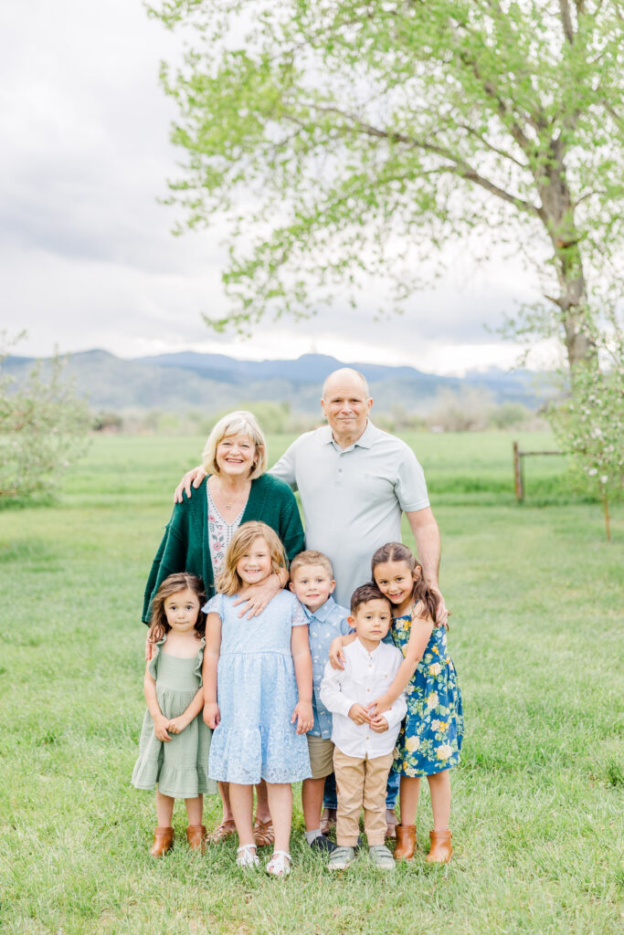 Grandparents stand behind their five young grandkids during Lantzy Extended Family Session at Ya Ya Orchard in Longmont, CO