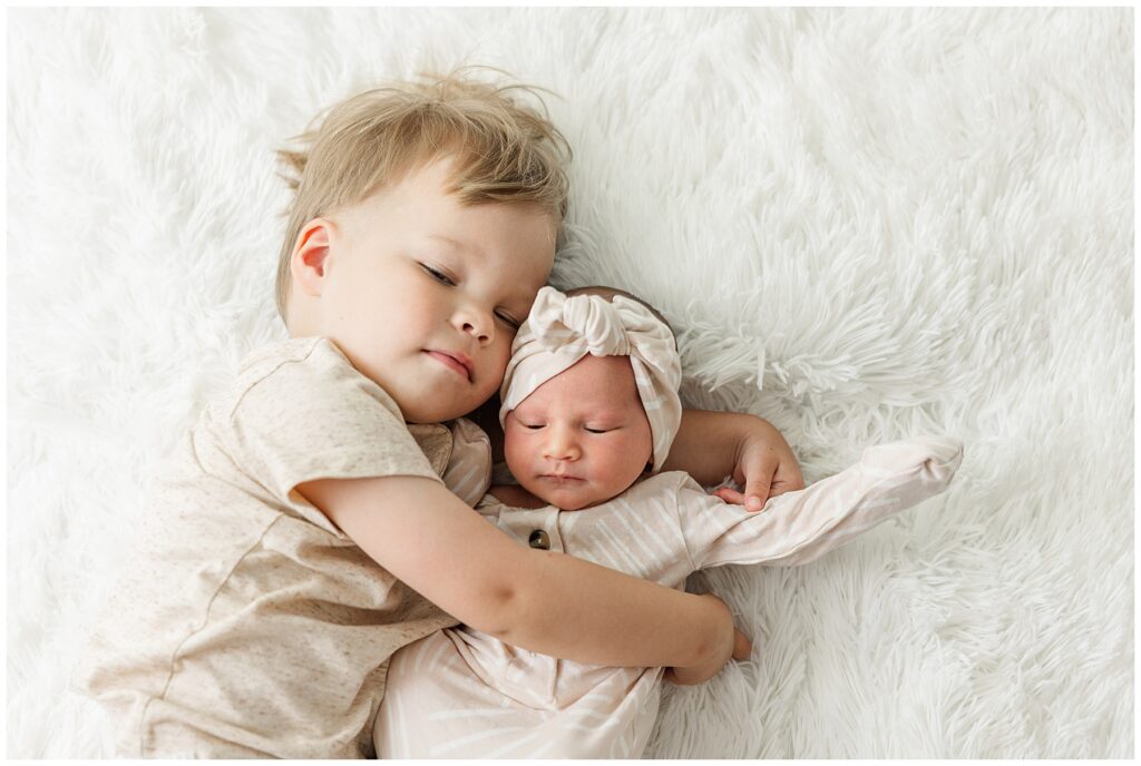 Toddler boy snuggled his little newborn sister during Peterson family newborn session in Fort Collins, CO