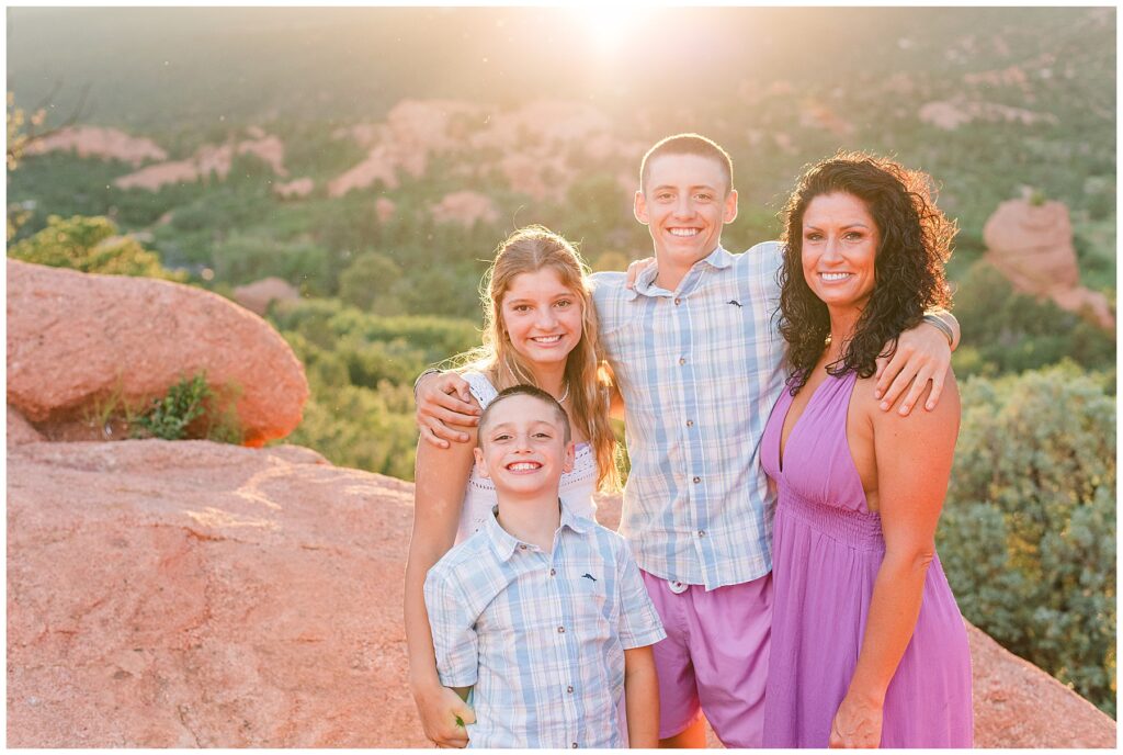 Family stand posing in front of mountains as the sun sets at Garden of the Gods in Colorado Springs