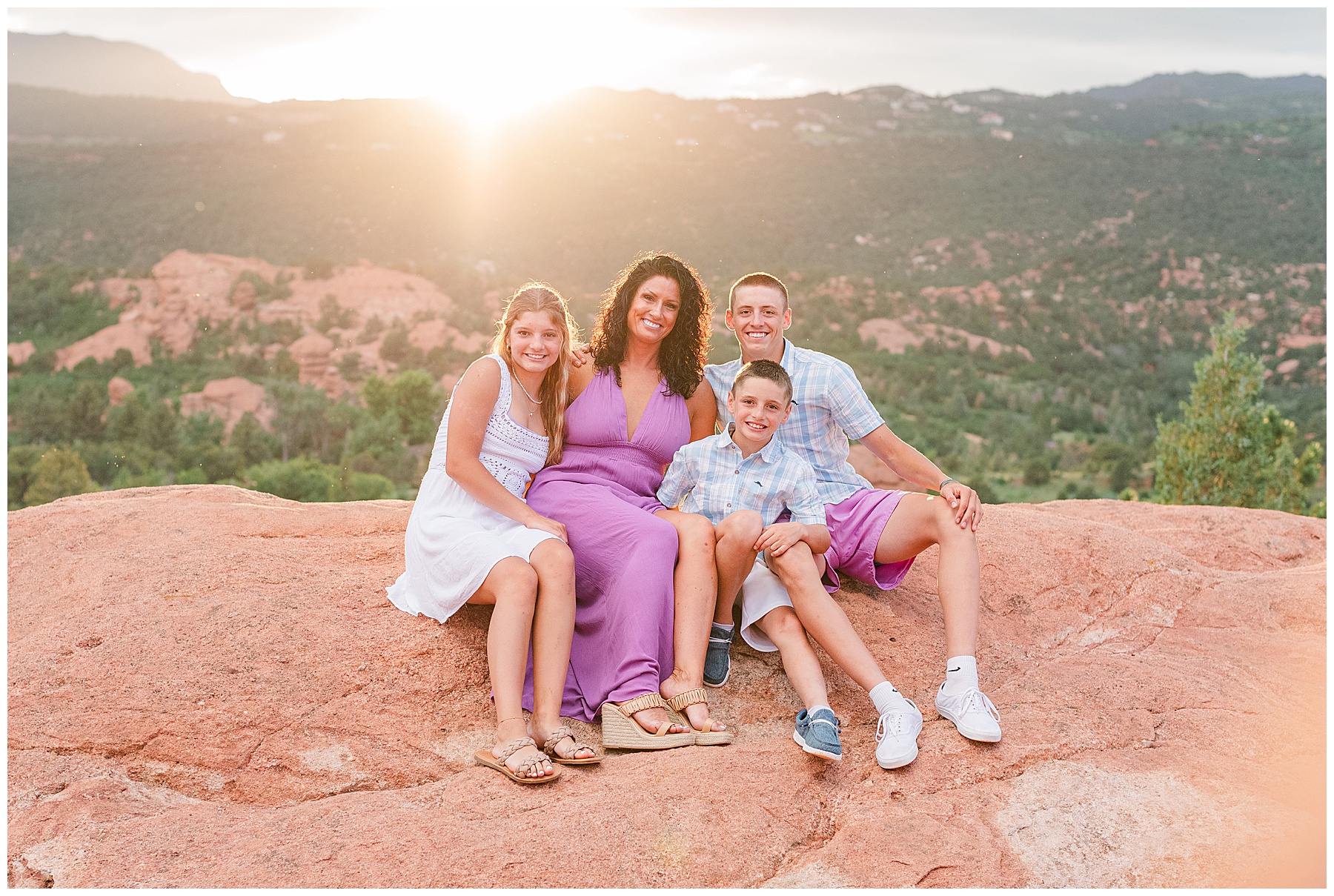 Mom sits with her three children as the sun sets below a mountain in Northern Colorado for family photos with Catherine Chamberlain Photography