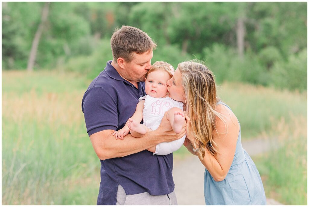 Mother and father kiss their baby girl on the cheek for light and airy photos by Catherine Chamberlain Photography based in Colorado