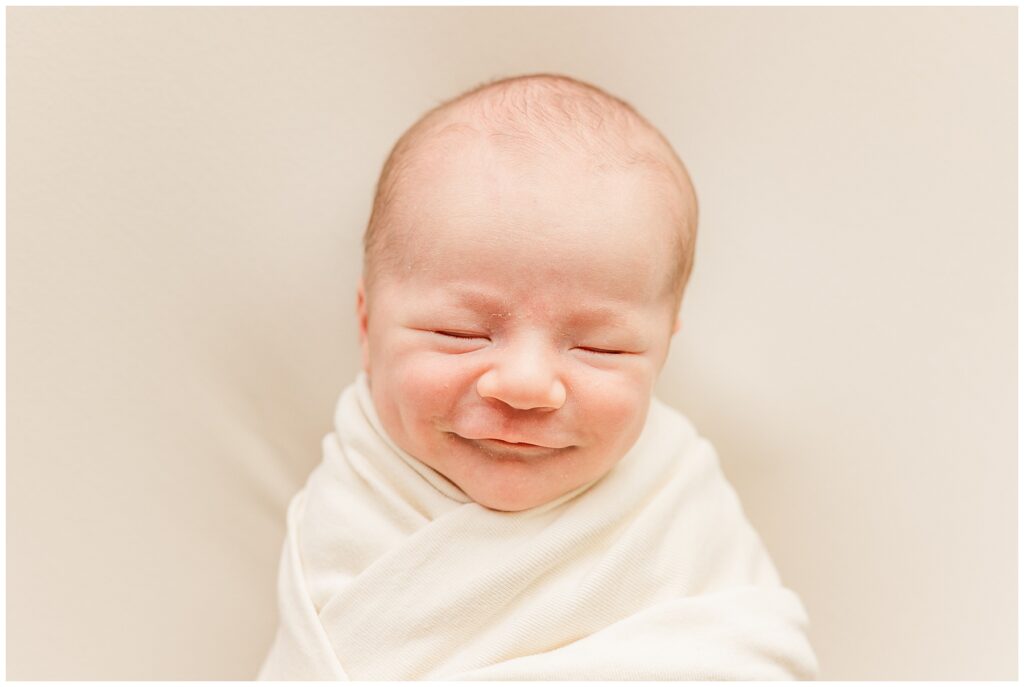 Newborn smiles in his sleep during this in-home Colorado newborn session