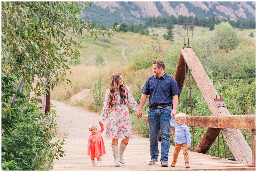 Mom, dad, and their two kids pose on a bridge at South Mesa Trailhead in Boulder Colorado for the Power Family Boulder Session