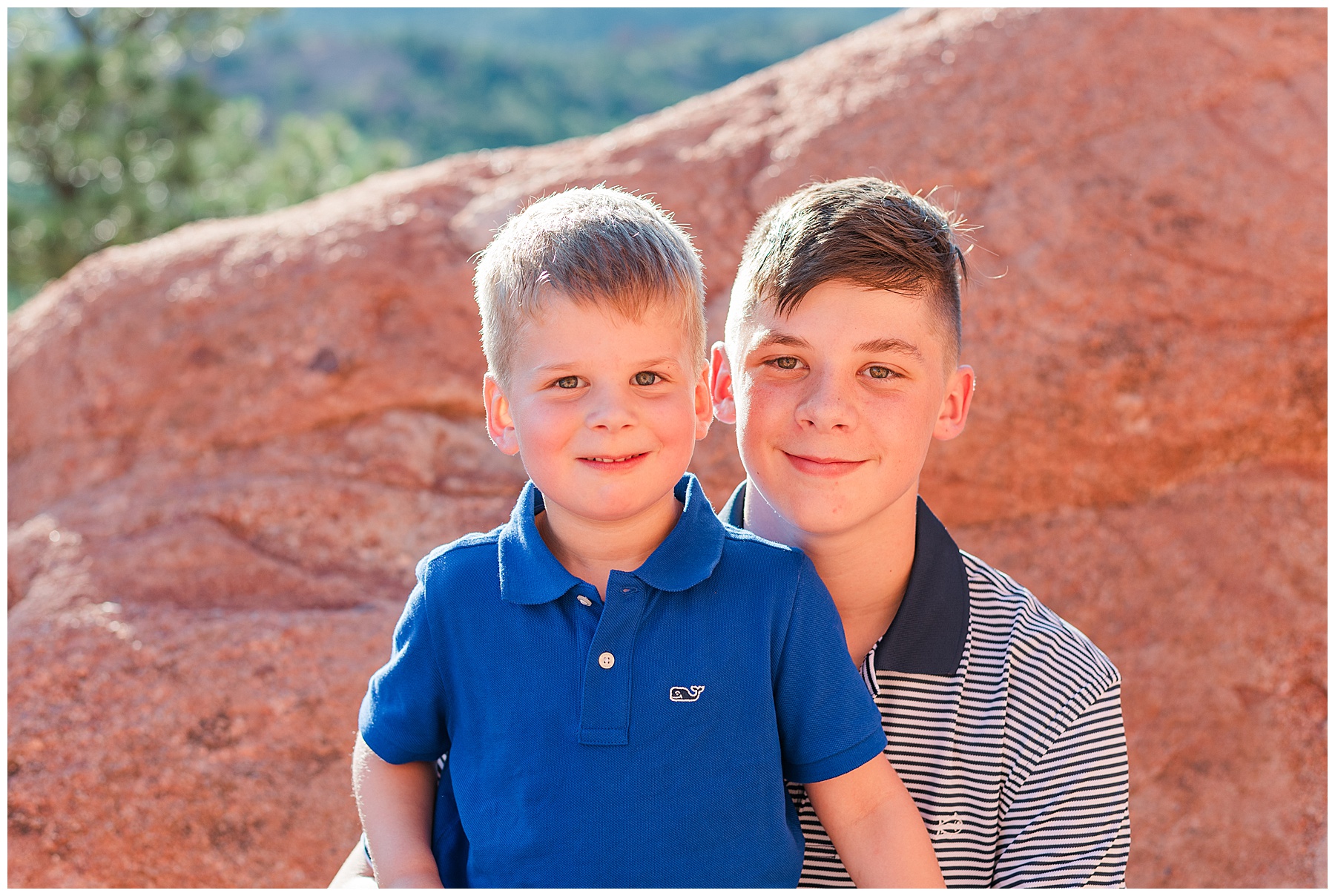 Older brother holds his little brother on his lap as they pose for light and airy photos with Catherine Chamberlain Photography based in Northern Colorado