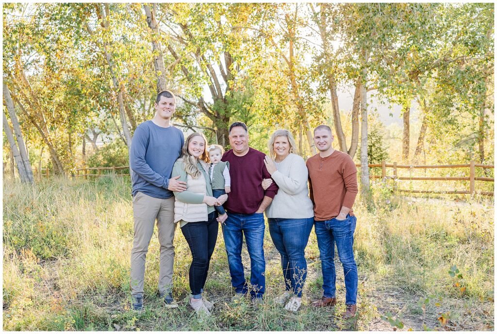 Family of six stand closely with golden trees behind them for the Stute Family Outdoor Session in Northern Colorado