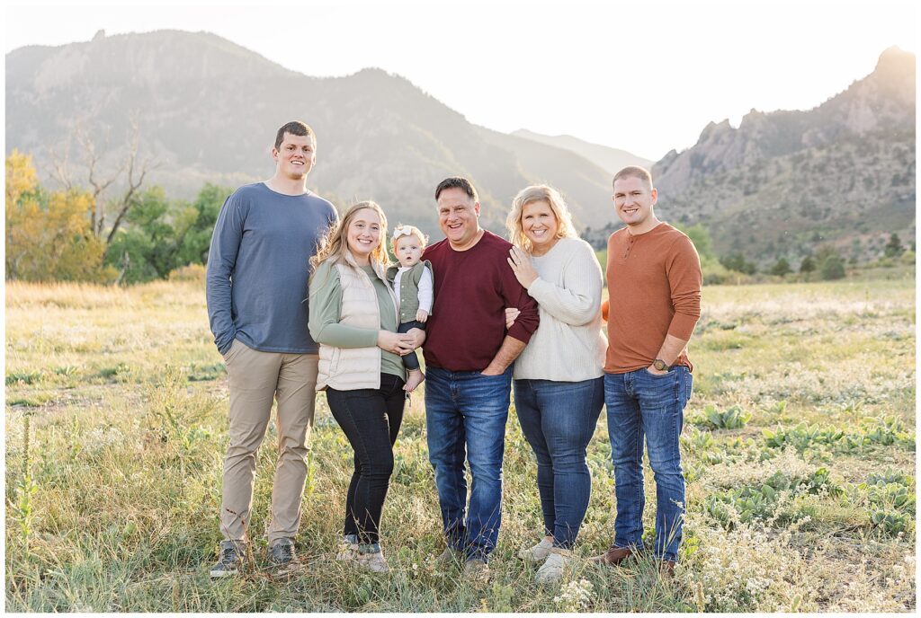 Family of six pose in front of a mountain with fall colored outfits