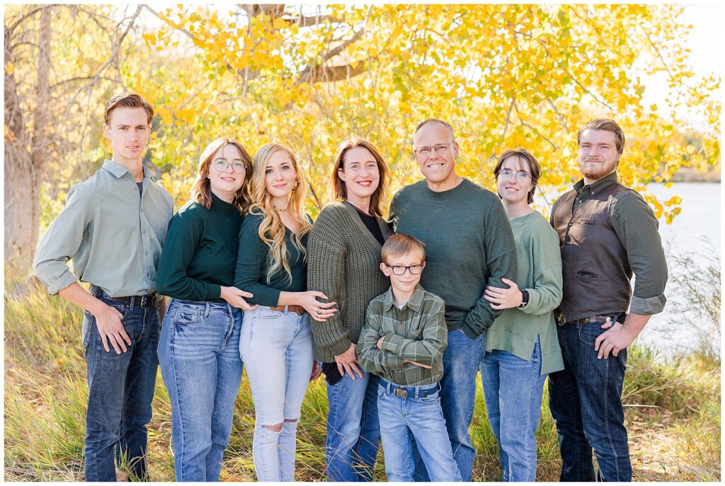 Extended family stands in front of golden aspen trees for Golden Ponds Fall Minis in Longmont, CO
