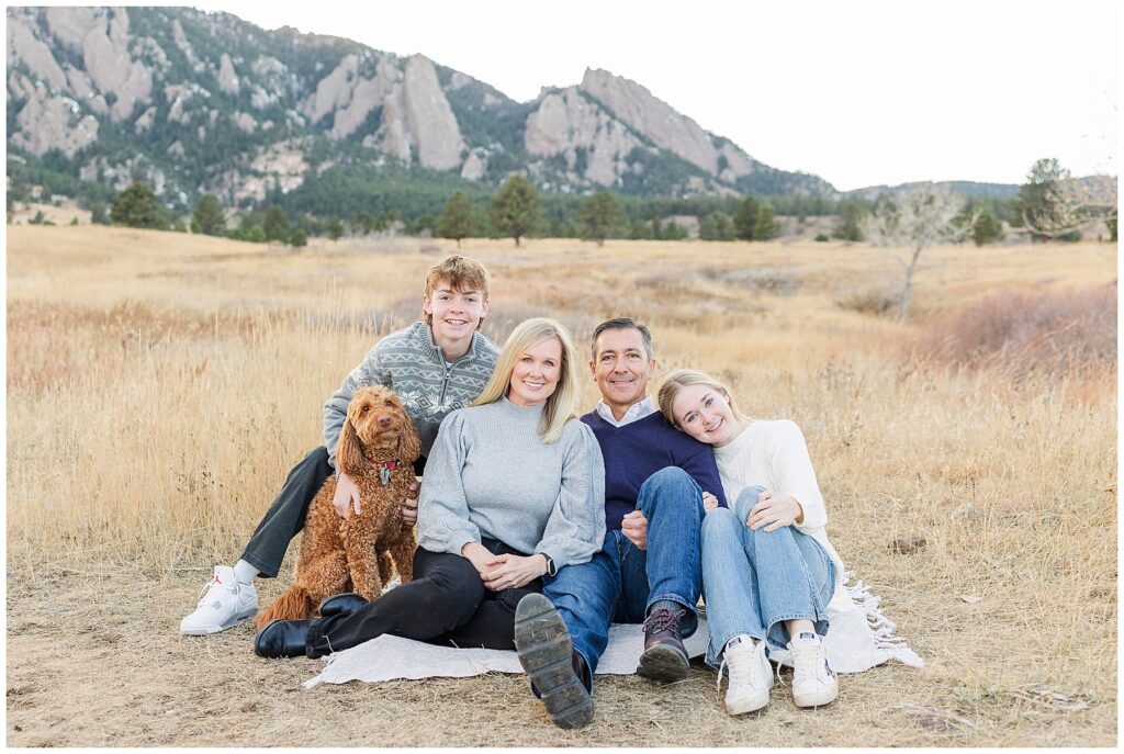 Family of four pose with their family dog for light and airy outdoor photos