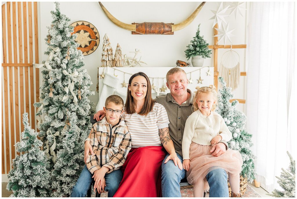 Family of four pose for cozy southwest Christmas minis at Sugarhill Studio in Longmont, CO