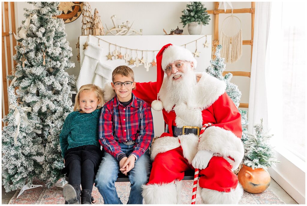 Two siblings sit for light and airy photos with Santa in Sugarhill Studio in Longmont