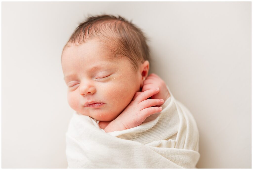 Precious newborn baby girl sleeps bundled up for Catherine Chamberlain Photography