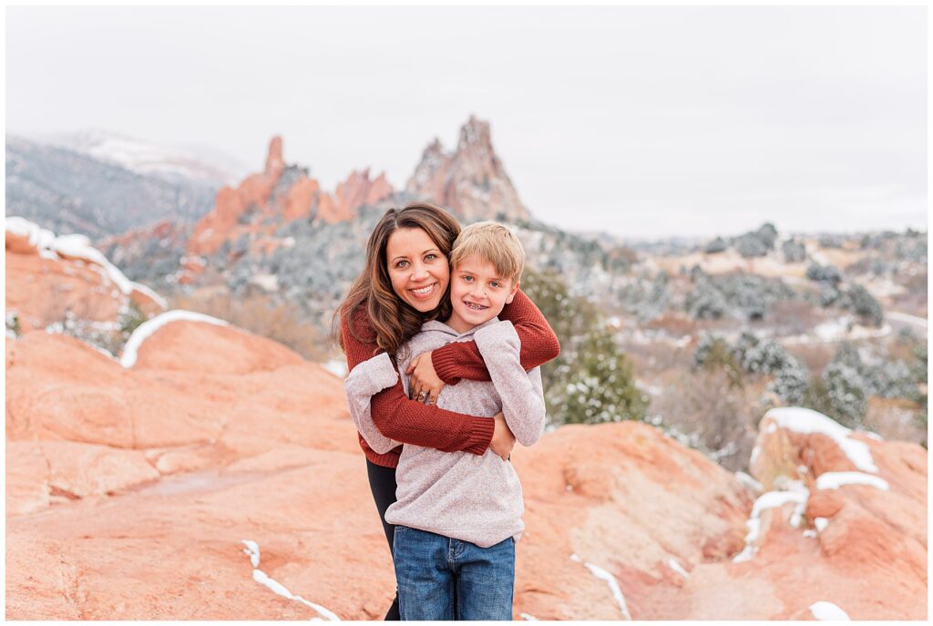 Mother hugs her young son from behind for mini sessions at Garden of the Gods in Colorado