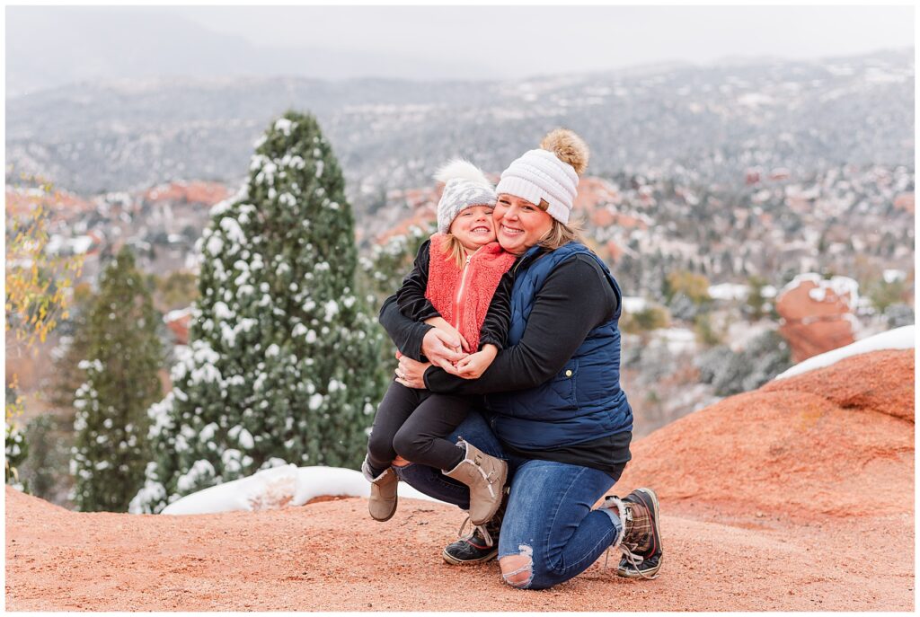 Mother and daughter pose with their pom hats at Garden of the Gods in the snow
