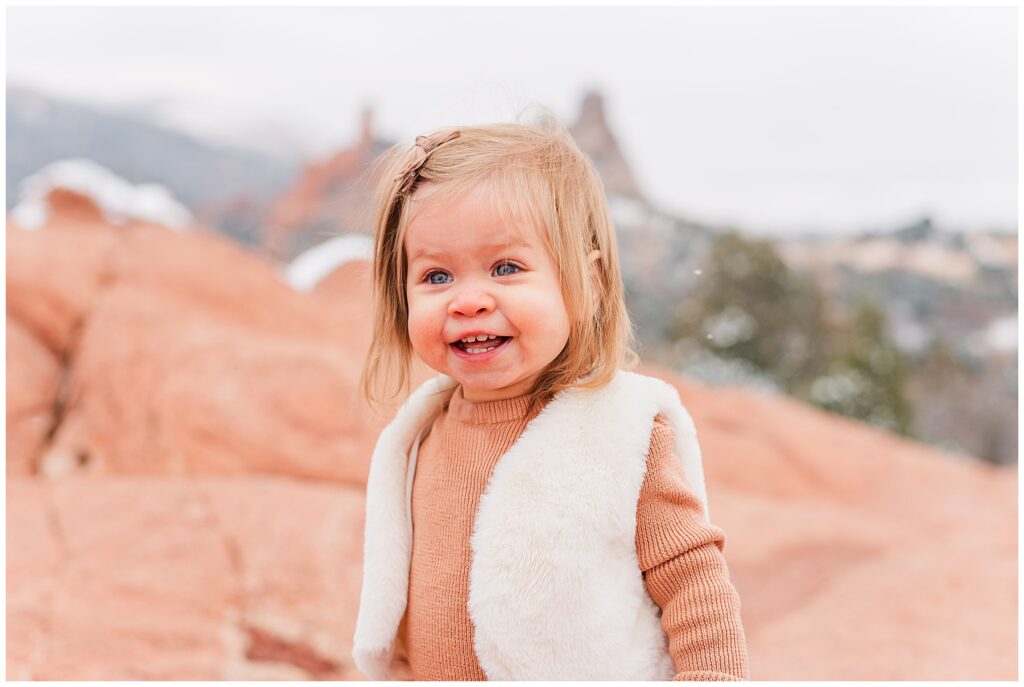 Close up of toddler girl smiling for snowy outdoor family minis in Colorado Springs, CO