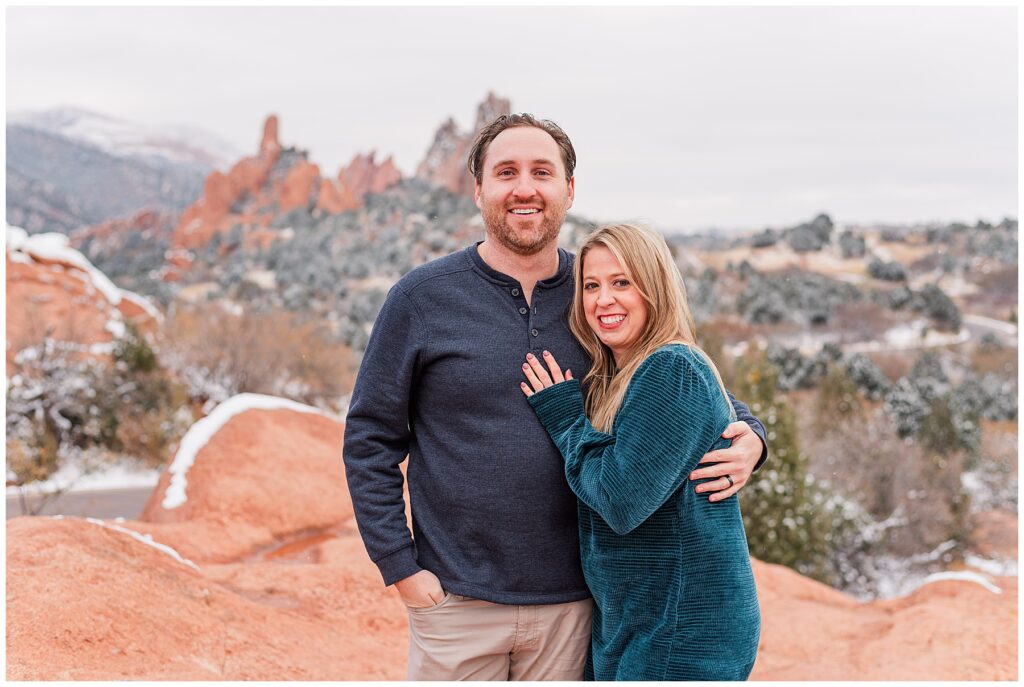 Couple pose with their arms around each other for light and airy snowy outdoor family minis in Colorado Springs, CO with Catherine Chamberlain Photography based out of Longmont, CO
