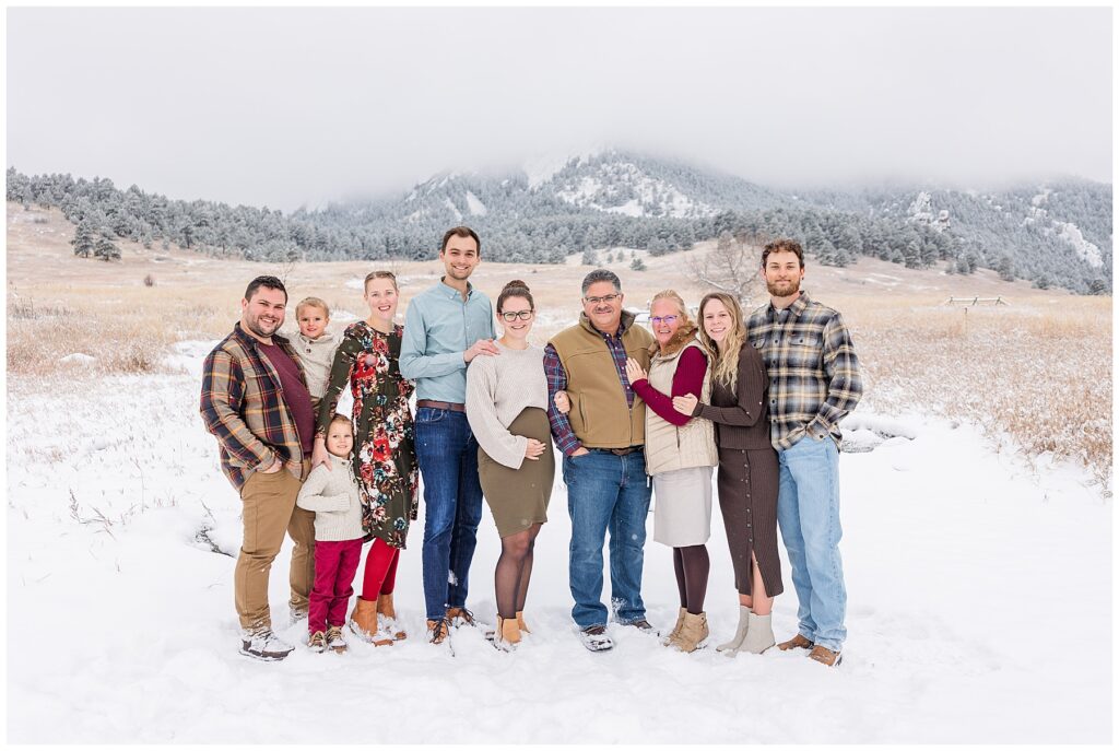 Family of ten pose in front of the Boulder Flatirons for a snowy extended family session by Catherine Chamberlain Photography
