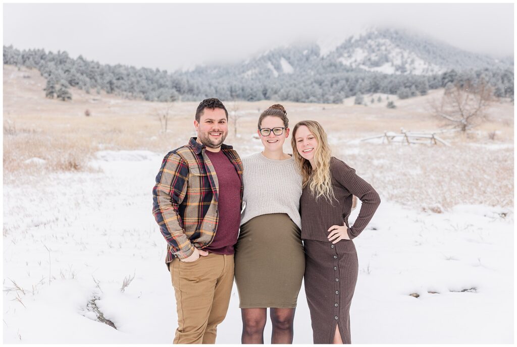 Three grown siblings pose with their arms around each other for outdoor photos