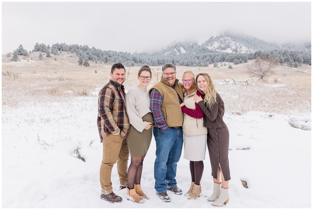 Family of five pose with snow on the ground for an extended family session with family photographer Catherine Chamberlain