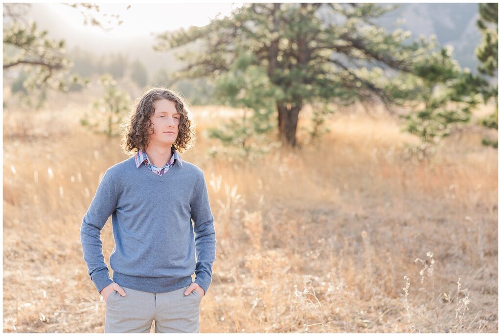 Boy stands with hands in his pockets for senior photos in Colorado