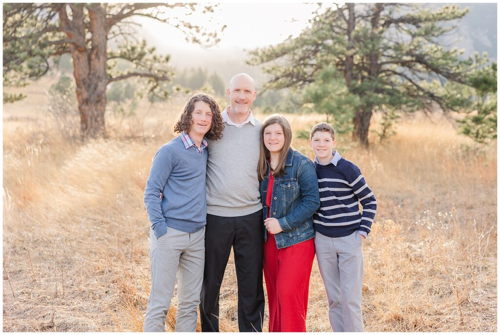 Dad puts his arms around his three teenaged children in Boulder Colorado