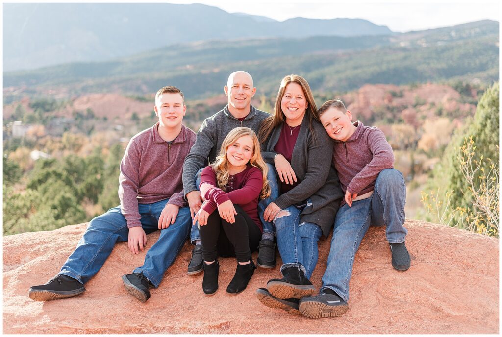 Family of five sit with the daughter in front on a rock for Colorado Springs Family Sessions at Garden of the Gods