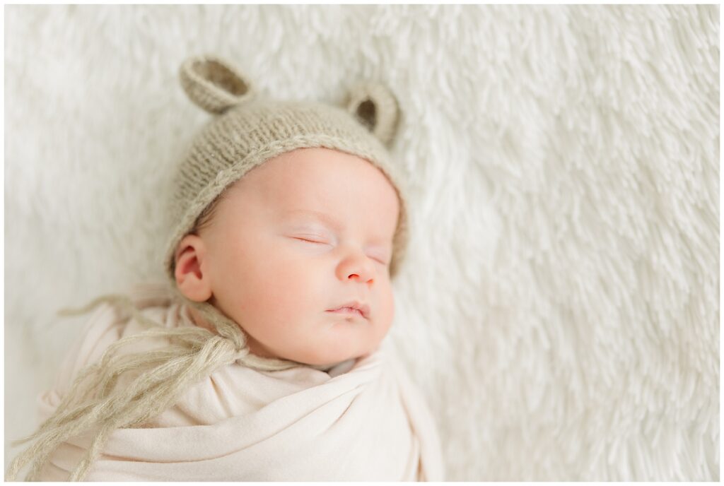 Newborn baby boy sleeps with a hat on for newborn photos in Colorado Springs