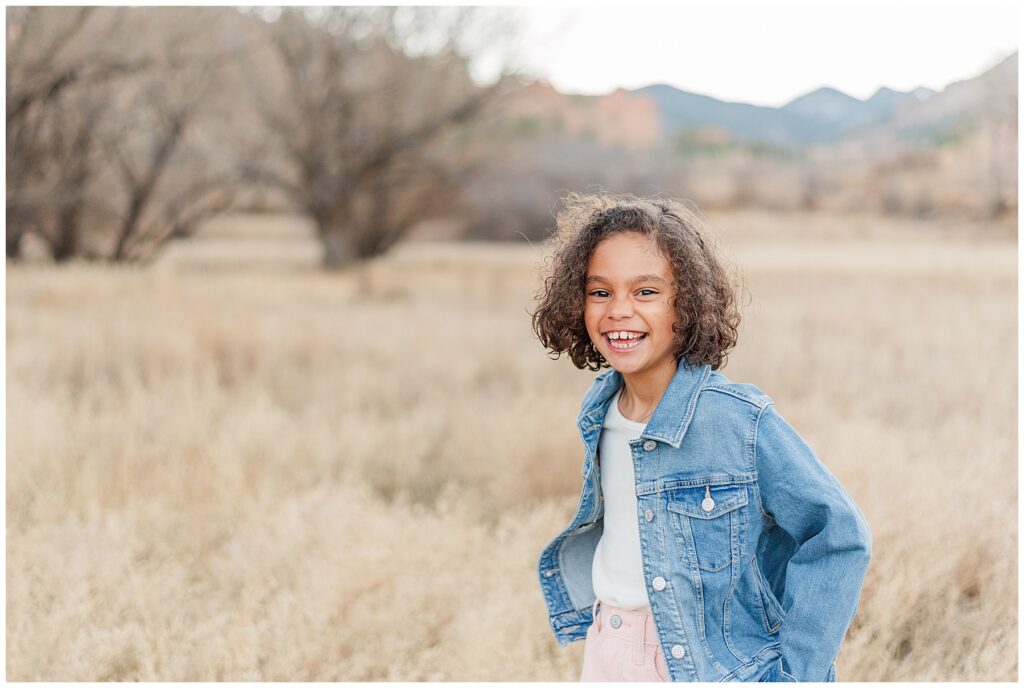 Little girl smiles and looks into the camera for light and airy photos with Catherine Chamberlain Photography