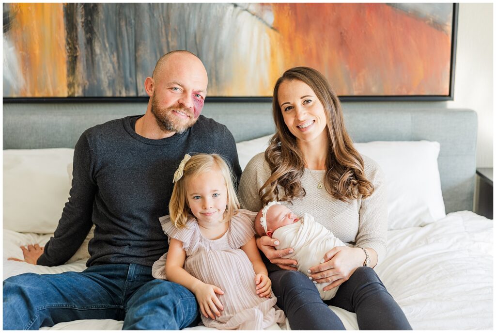 Family of four pose for lifestyle newborn photos