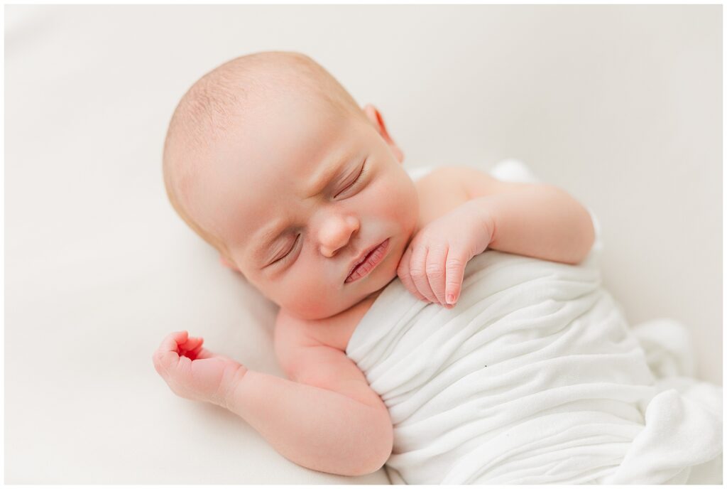 Newborn baby sleeps in neutral colored setting