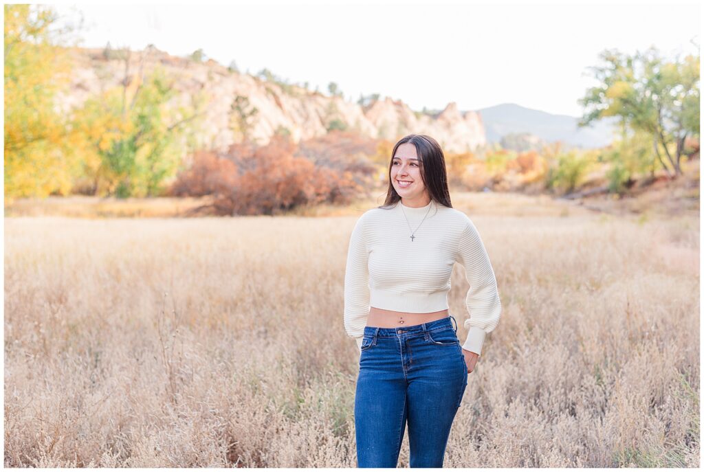 Girl looks off in the distance with mountains behind her for Colorado Springs Senior Session at Red Rocks Open Space with Catherine Chamberlain Photography
